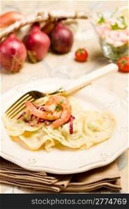 delicious italian homemade ravioli with shrimps and golden fork