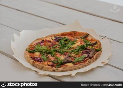 Delicious italian pizza served on white wooden table