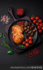 Delicious juicy chicken thighs baked with salt, spices and herbs in a ceramic plate on a dark concrete background