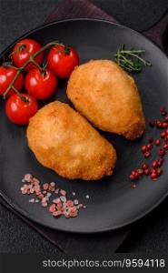 Delicious juicy cutlets or meatballs from minced chicken with salt and spices on a textured concrete background