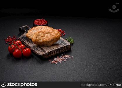 Delicious juicy cutlets or meatballs from minced chicken with salt and spices on a textured concrete background