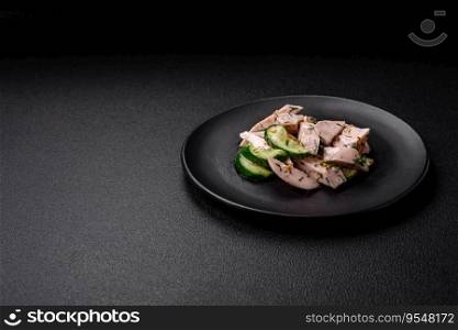 Delicious juicy fresh salad of cucumbers and grilled chicken slices, with french mustard, salt and spices on a dark concrete background