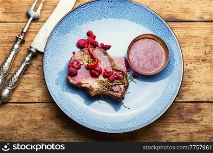 Delicious juicy fried pork with raspberry sauce. Fried steak with raspberry sauce