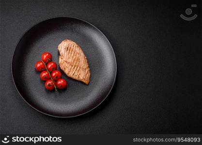 Delicious juicy grilled chicken fillet with salt, spices and herbs on a dark concrete background