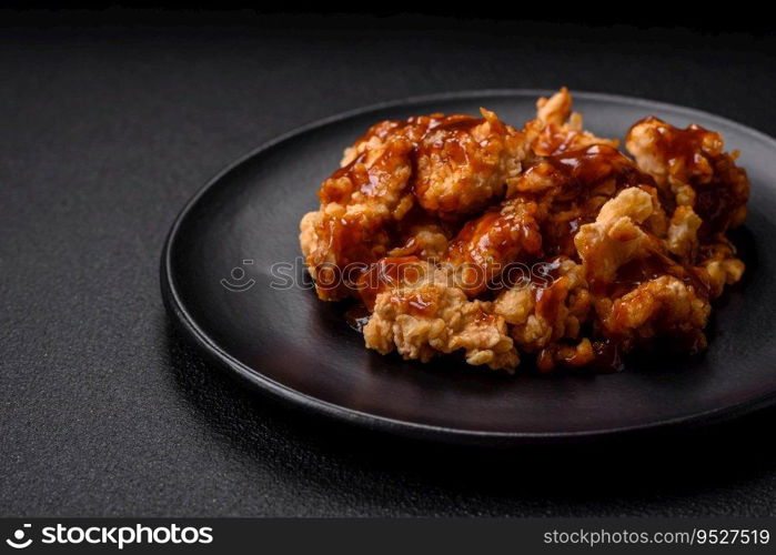 Delicious juicy grilled chicken meat bites with salt, spices and herbs on a dark concrete background