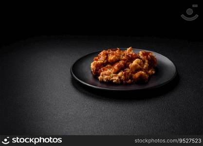 Delicious juicy grilled chicken meat bites with salt, spices and herbs on a dark concrete background