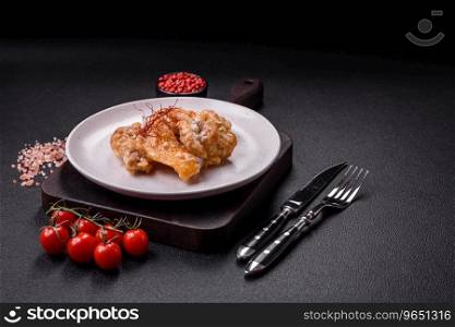 Delicious juicy grilled chicken pieces in sweet and sour sauce with salt and spices on a ceramic plate