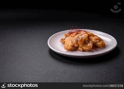 Delicious juicy grilled chicken pieces in sweet and sour sauce with salt and spices on a ceramic plate