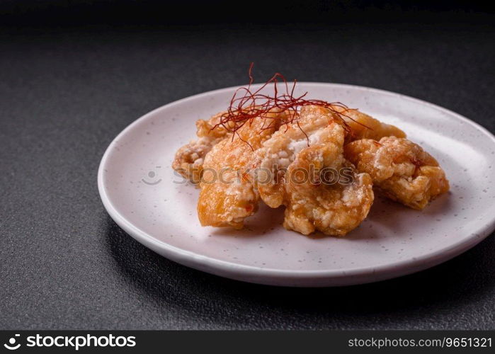 Delicious juicy grilled chicken pieces in sweet and sour sauce with salt and spices on a ceramic plate