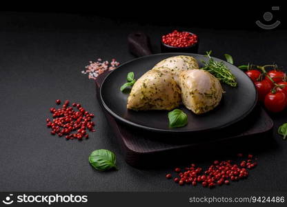 Delicious juicy grilled chicken with salt, spices and herbs with vegetables on a dark concrete background