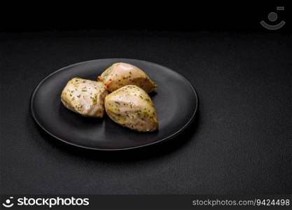 Delicious juicy grilled chicken with salt, spices and herbs with vegetables on a dark concrete background