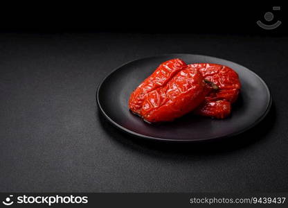 Delicious juicy grilled peppers with spices and herbs on a dark concrete background