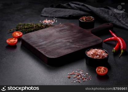 Delicious juicy grilled pork steak with spices and herbs on a wooden cutting board