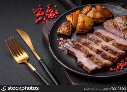 Delicious juicy pork or beef steak grilled with salt, spices and herbs on a textured concrete background