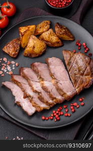 Delicious juicy pork or beef steak grilled with salt, spices and herbs on a textured concrete background