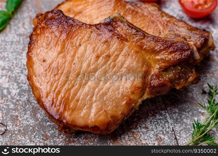 Delicious juicy pork or beef steak with salt, spices and herbs on a textured concrete background
