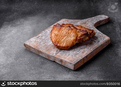 Delicious juicy pork or beef steak with salt, spices and herbs on a textured concrete background