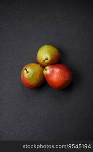 Delicious juicy sweet green pear with red side on dark textured concrete background