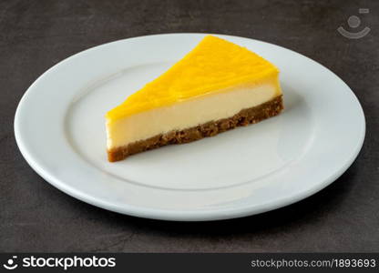 Delicious lemon cheesecake on black stone table