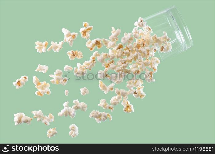 Delicious looking fresh popcorn falling from a suspended glass on a light background. Fast food and fun concept.