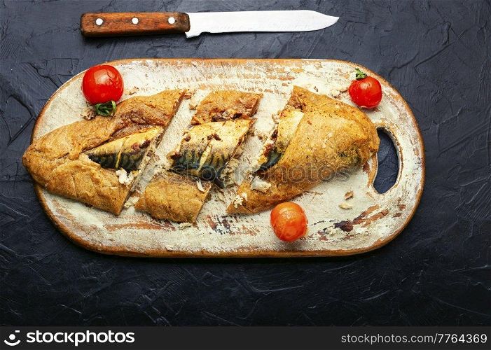 Delicious mackerel fish baked in dough on cutting board. Scomber fish baked in dough.