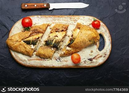 Delicious mackerel fish baked in dough on cutting board. Scomber fish baked in dough.