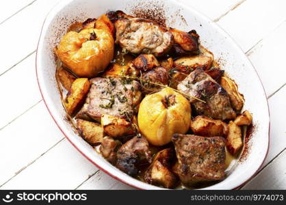 Delicious meat cooked with autumn fruits in tray. Meat baked with apples and quince