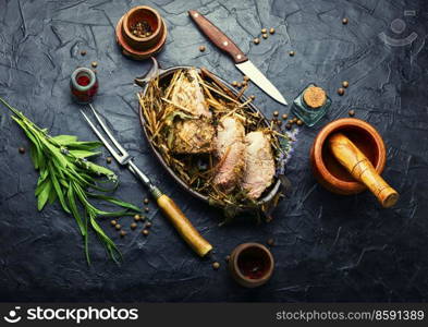 Delicious meat roasted in fresh hay. Baked pork meat in spicy herbs.Autumn food. Roast pork in hay with herbs