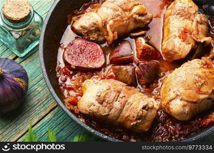 Delicious meat sausage with autumn figs in iron cast pan. Meat fried rolls, stewed meat