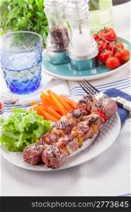 Delicious meat skewers with carrots and salad