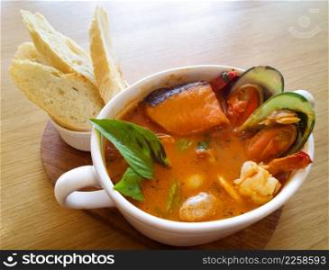 Delicious mediterranean seafood soup on wooden table