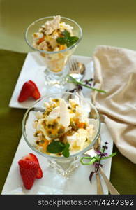 Delicious meringue dessert with pawpaw and passionfruit sauce with strawberries.