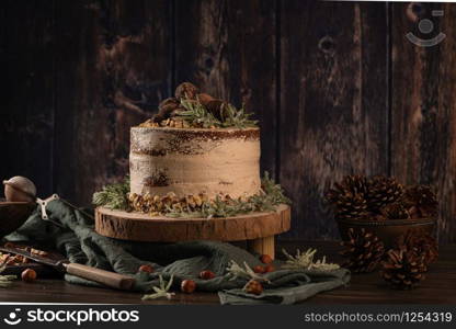 Delicious naked chocolate and hazelnuts cake on table rustic wood kitchen countertop.