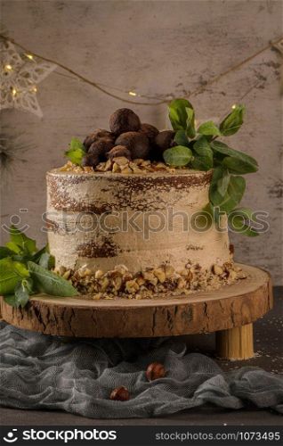 Delicious naked coffee and hazelnuts cake on table rustic wood kitchen countertop.