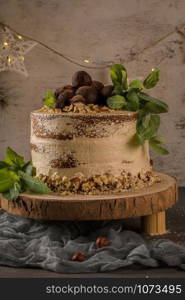 Delicious naked coffee and hazelnuts cake on table rustic wood kitchen countertop.