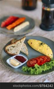 Delicious omelette with tomatoes and fruits on the table