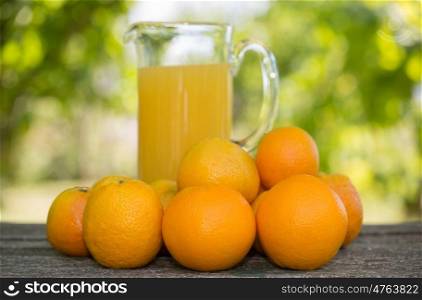 delicious orange juice and oranges on table in garden