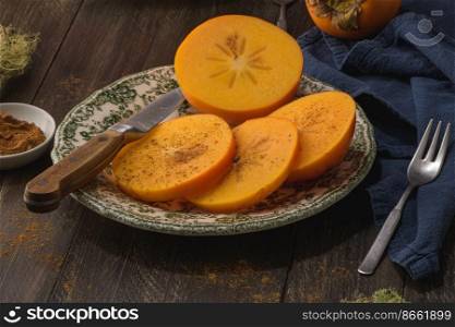Delicious orange persimmons on wooden table.