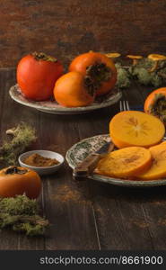 Delicious orange persimmons on wooden table.