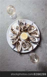 Delicious oysters with slice of lemon, top view with place for text. Oysters on the plate
