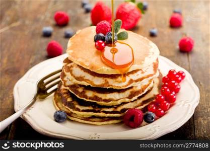 delicious pancakes on wooden table with fruits