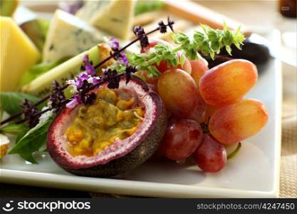 Delicious passionfruit with fresh grapes, basil flowers and a variety of cheeses.