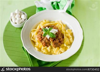 delicious pasta with tomato meat sauce and mozzarella chips over it