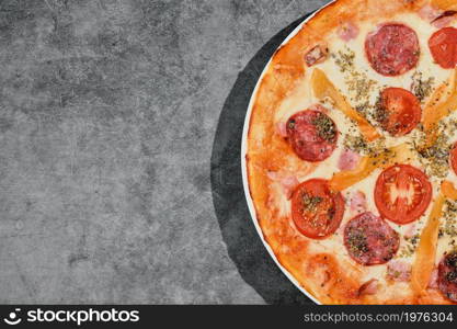 Delicious pepperoni pizza on a gray concrete background. Top view of hot freshly made pepperoni pizza. Layout with space for copying text. Banner idea