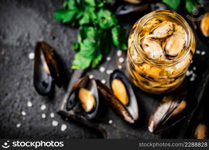 Delicious pickled mussels with parsley on the table. On a black background. High quality photo. Delicious pickled mussels with parsley on the table. 