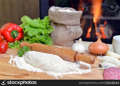 delicious pizza dough, spices and vegetables on wooden table