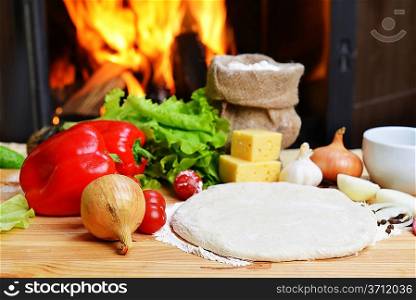 delicious pizza dough, spices and vegetables on wooden table