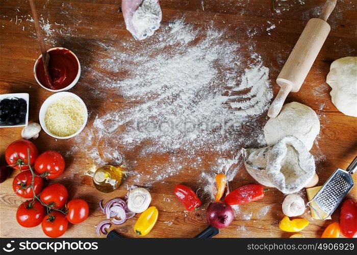 Delicious pizza dough, spices and vegetables on wooden table