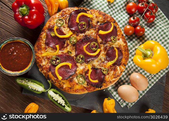 Delicious pizza served on wooden table. Pizza cooking ingredients