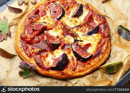 Delicious pizza with ham and autumn figs. Tasty meat pizza with fig